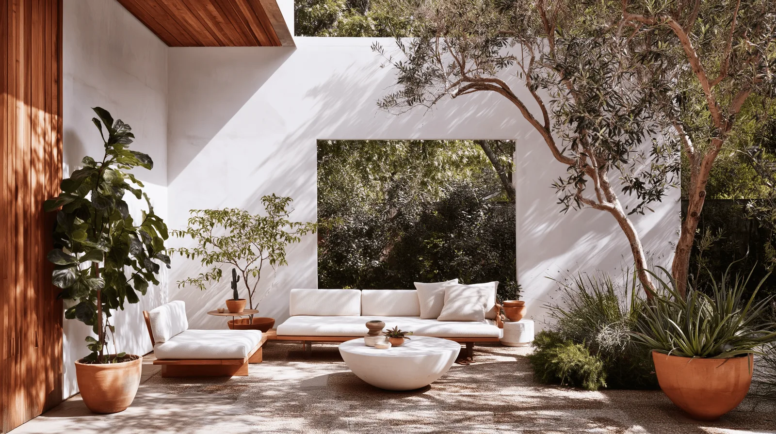 A rendered courtyard with a low white modular sofa, a round stone table and an established olive tree